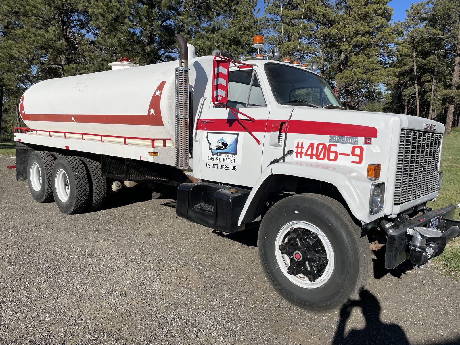 White GMC Brigadier 3,000-gallon water tender #406-9 with red stripe and 406 H2O LLC door decal