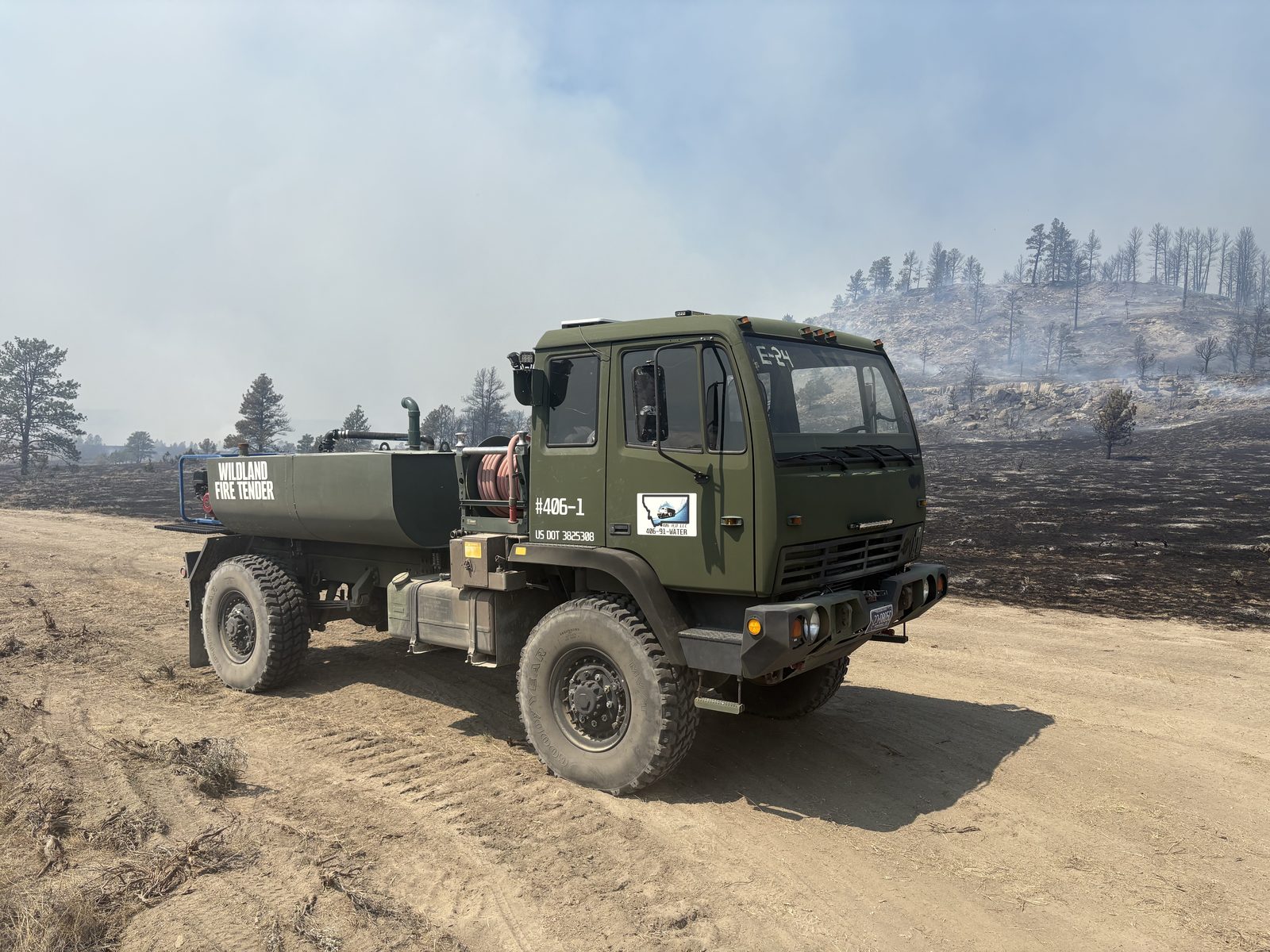Olive drab LMTV 4x4 wildland fire tender #406-1 on a burned hillside